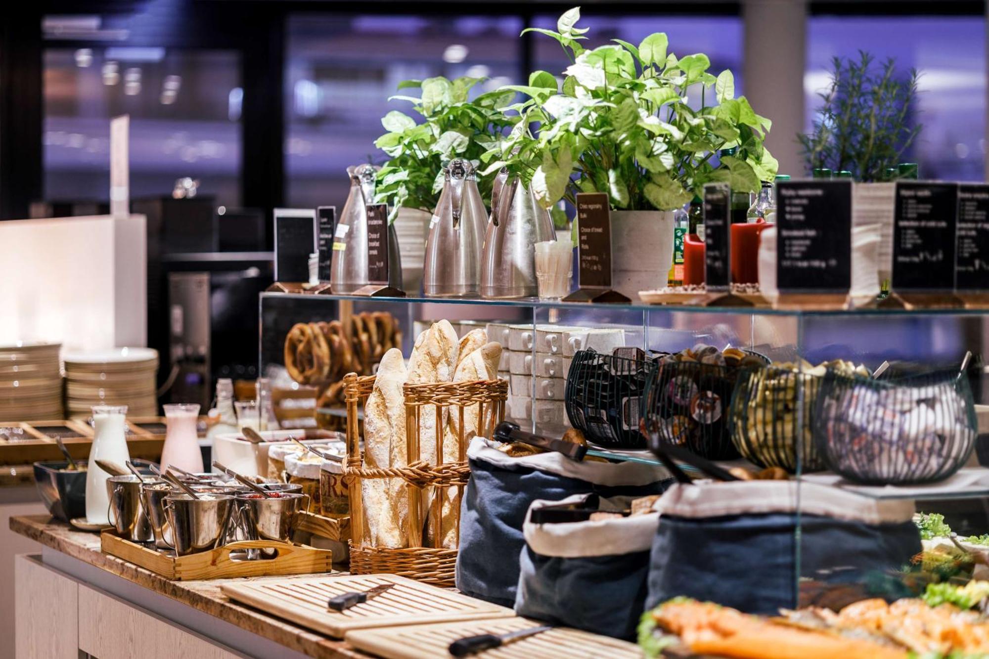 Radisson Blu Resort Swinoujscie Ngoại thất bức ảnh The photo depicts a beautifully arranged buffet or food display area. It features various items such as:

- Several glass or metal containers, possibly holding beverages or condiments.
- Fresh greenery in pots, suggesting a focus on natural elements.