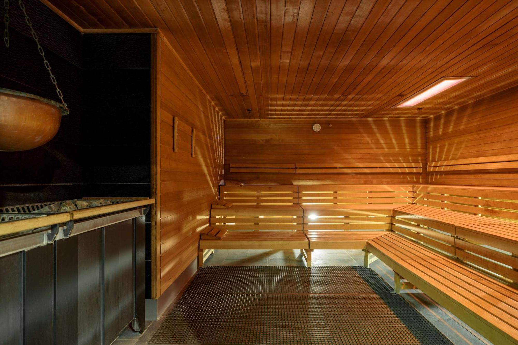 Radisson Blu Resort Swinoujscie Ngoại thất bức ảnh The photo shows the interior of a sauna. The walls and benches are made of wood, creating a warm and inviting atmosphere. There is a heater, likely for generating steam, and a metal rack connected to it, perhaps for holding stones or water. The desig