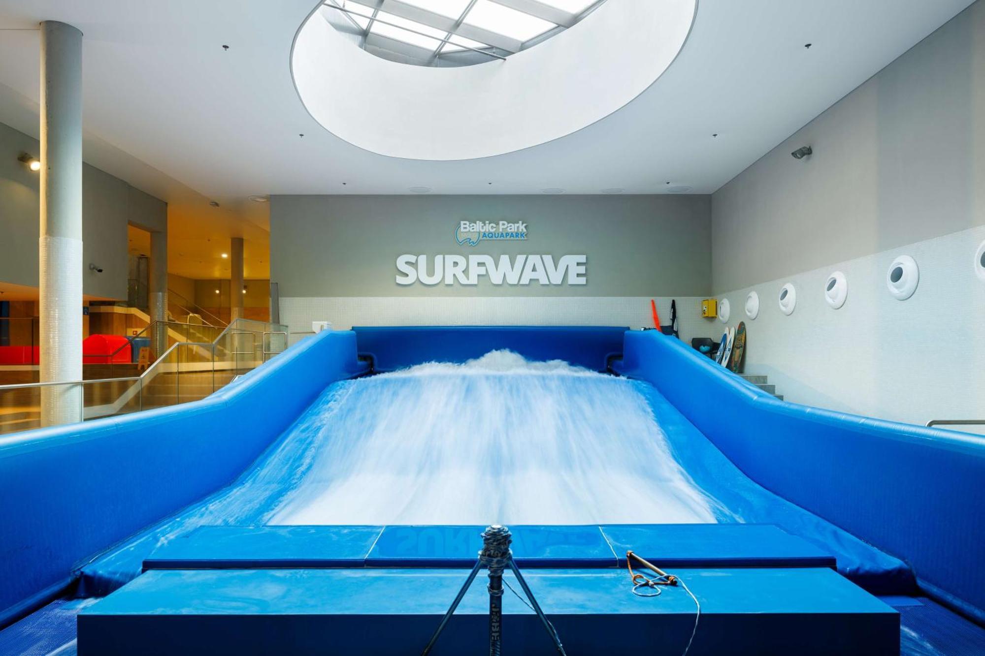Radisson Blu Resort Swinoujscie Ngoại thất bức ảnh The photo shows an indoor surfing attraction called "Surfwave." It features a large blue ramp with water flowing down it, creating a wave-like effect for surfing. Above the ramp, there is a sign that says "SURFWAVE." The area appears well-lit and mod